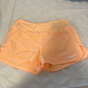 Orange Nike Dri-Fit shorts with a key pocket in back and lining still attached